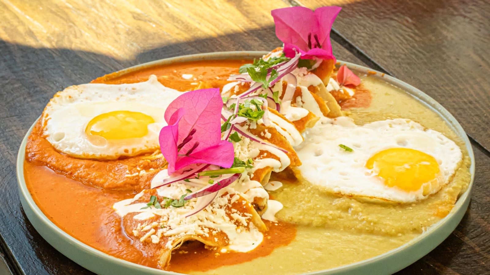 Huevos estrellados sobre tortilla con salsa, servidos con una flor